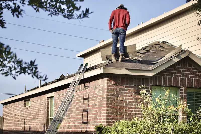 Professional roofer working on a residential roof in Loysburg